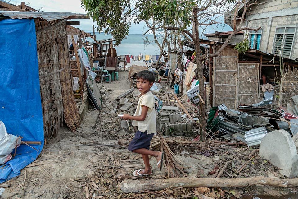 Child standing at destruction caused by Typhoon Haiyan, Philippines